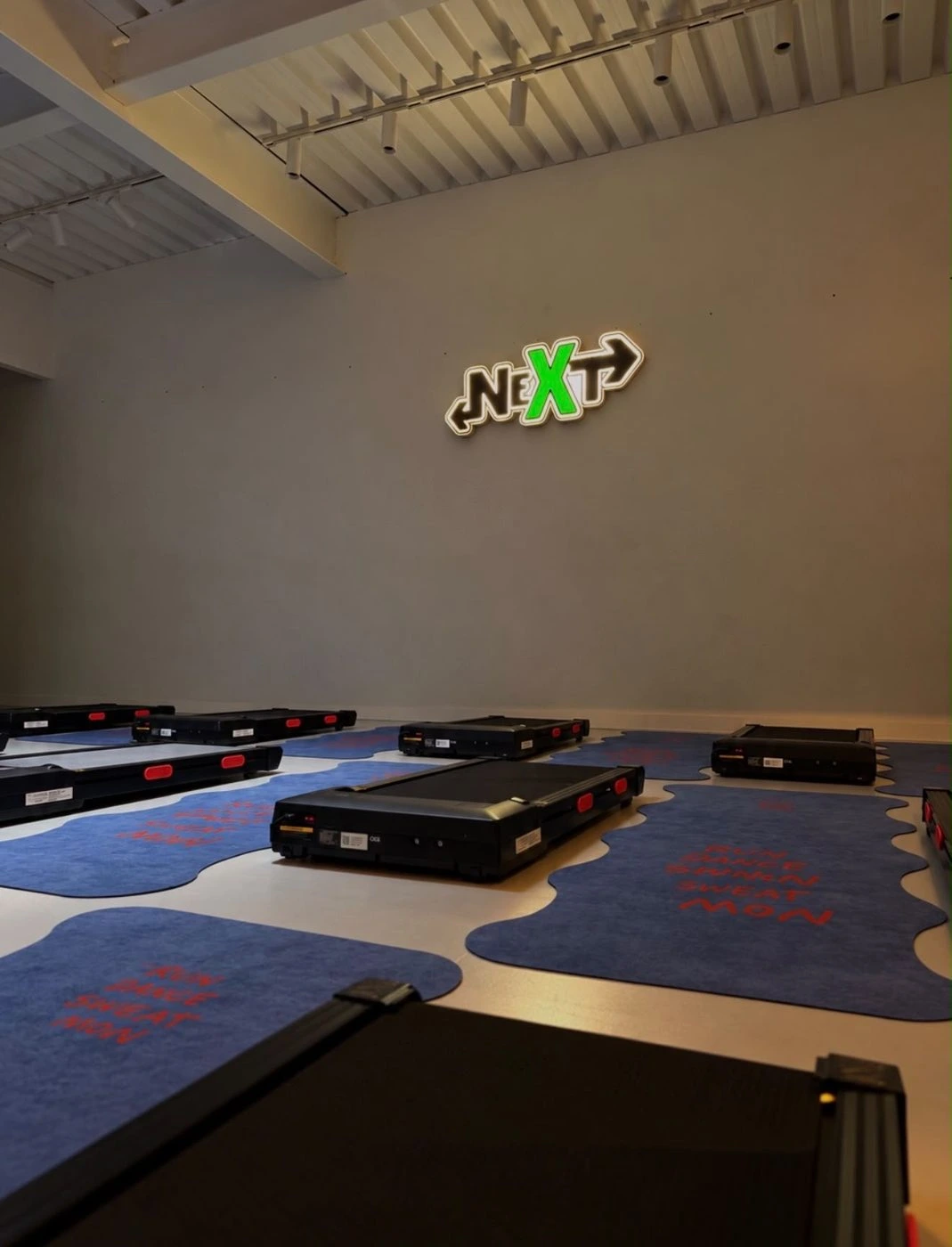 Tapis de treadmill sous l’enseigne lumineuse NEXT