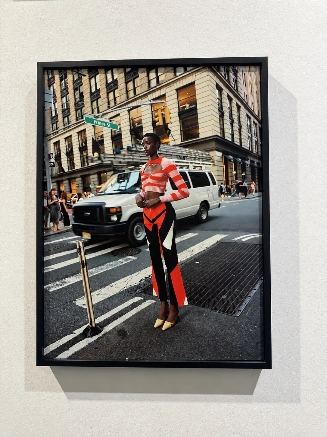 Photographie encadrée d’une femme en tenue rouge et noire dans une rue